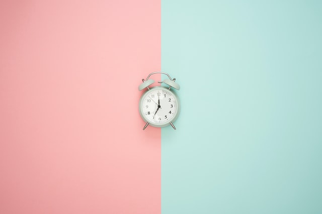 Alarm clock against pastel background