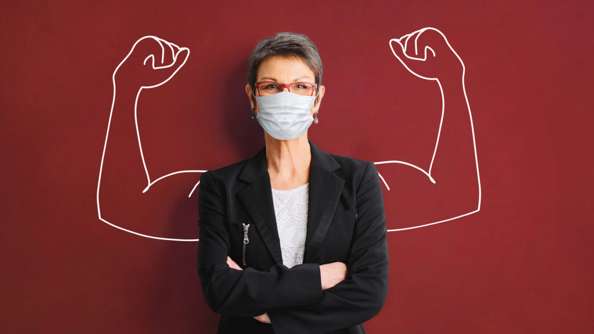 woman in medical face protection mask indoors on blue background
