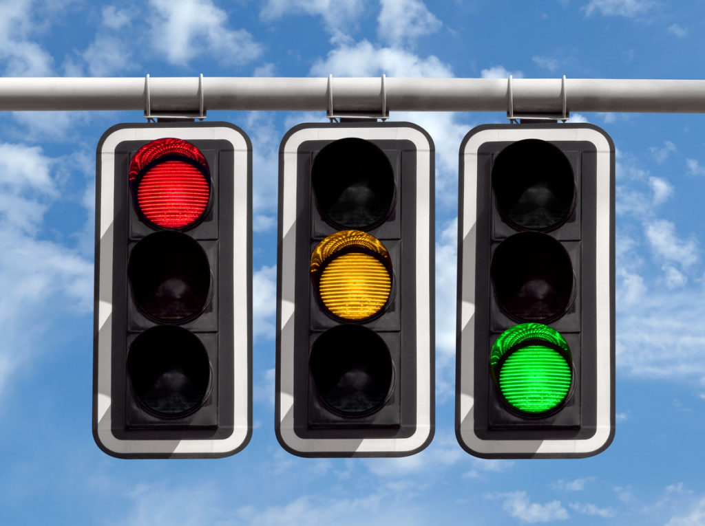Three traffic lights displaying different colours