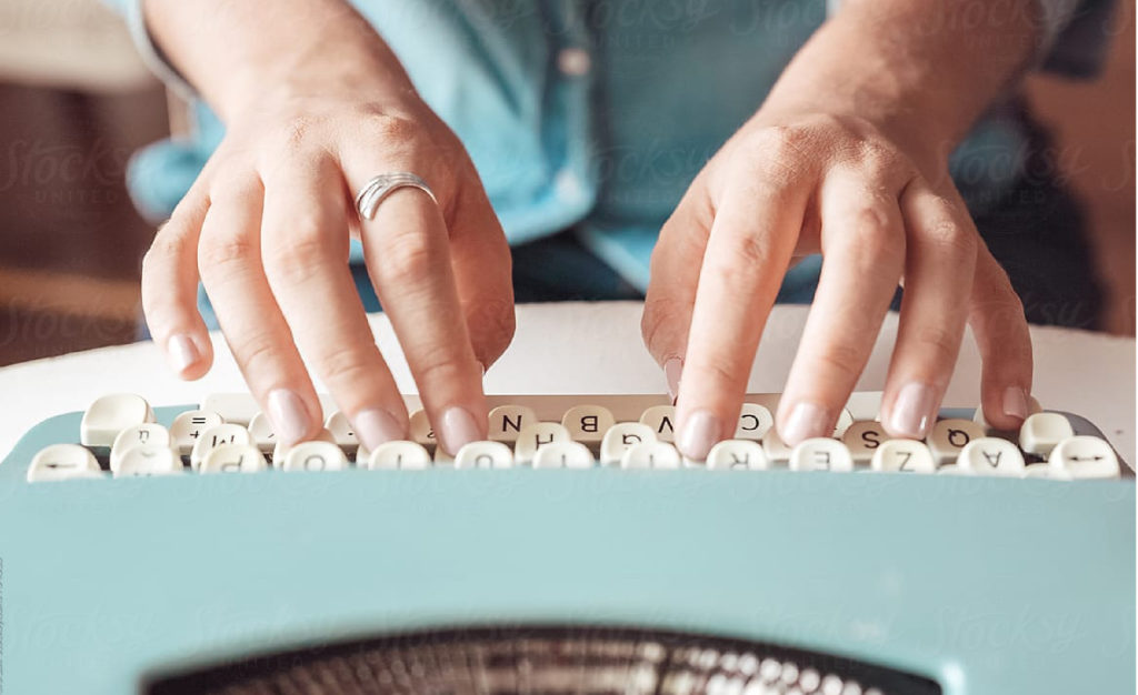 Fingers typing on a typewriter