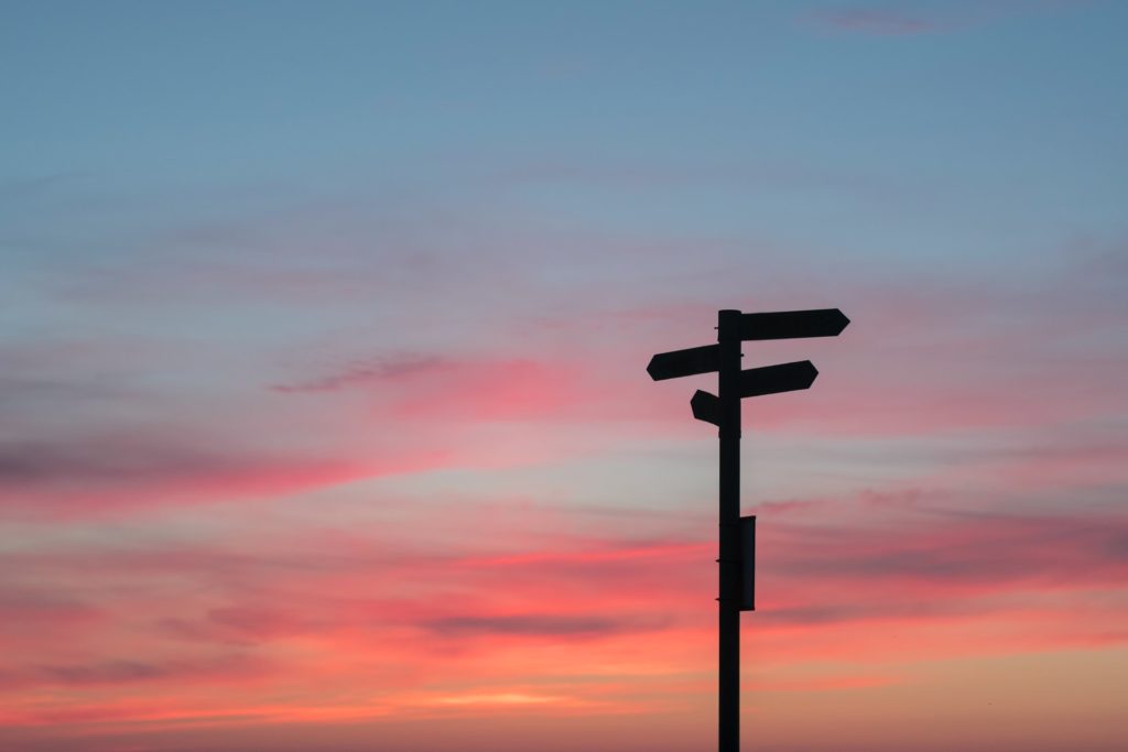Signpost against a sunset sky
