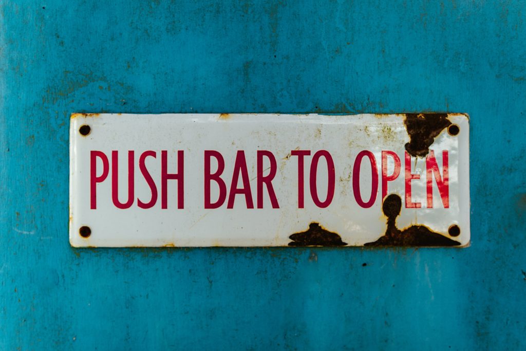 Weathered enamel sign against a blue wall