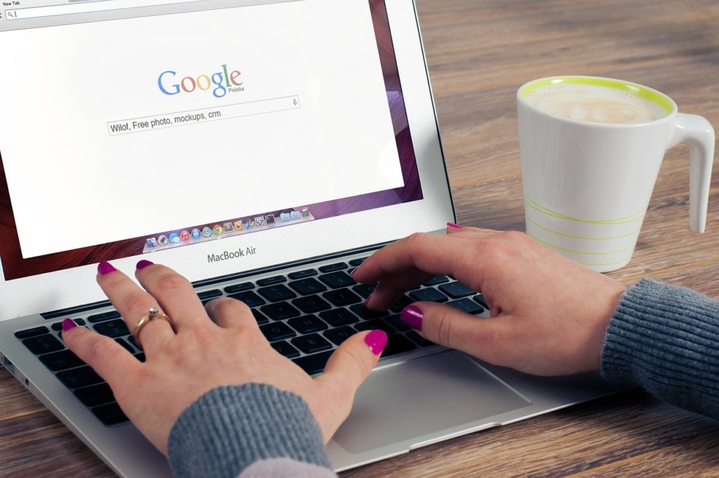 Close up of woman working on laptop computer searching Google