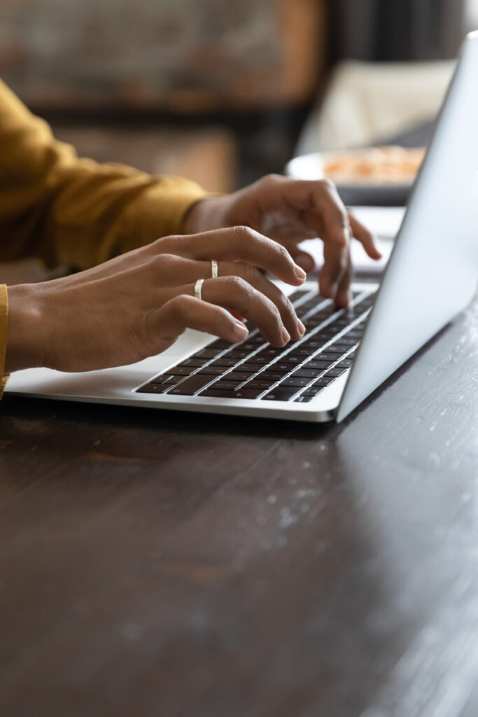 Close up cropped vertical view African female hands typing on laptop keyboard, student prepare task, studying on-line. Correspondence to client use e-mail, workflow use modern tech, freelance concept