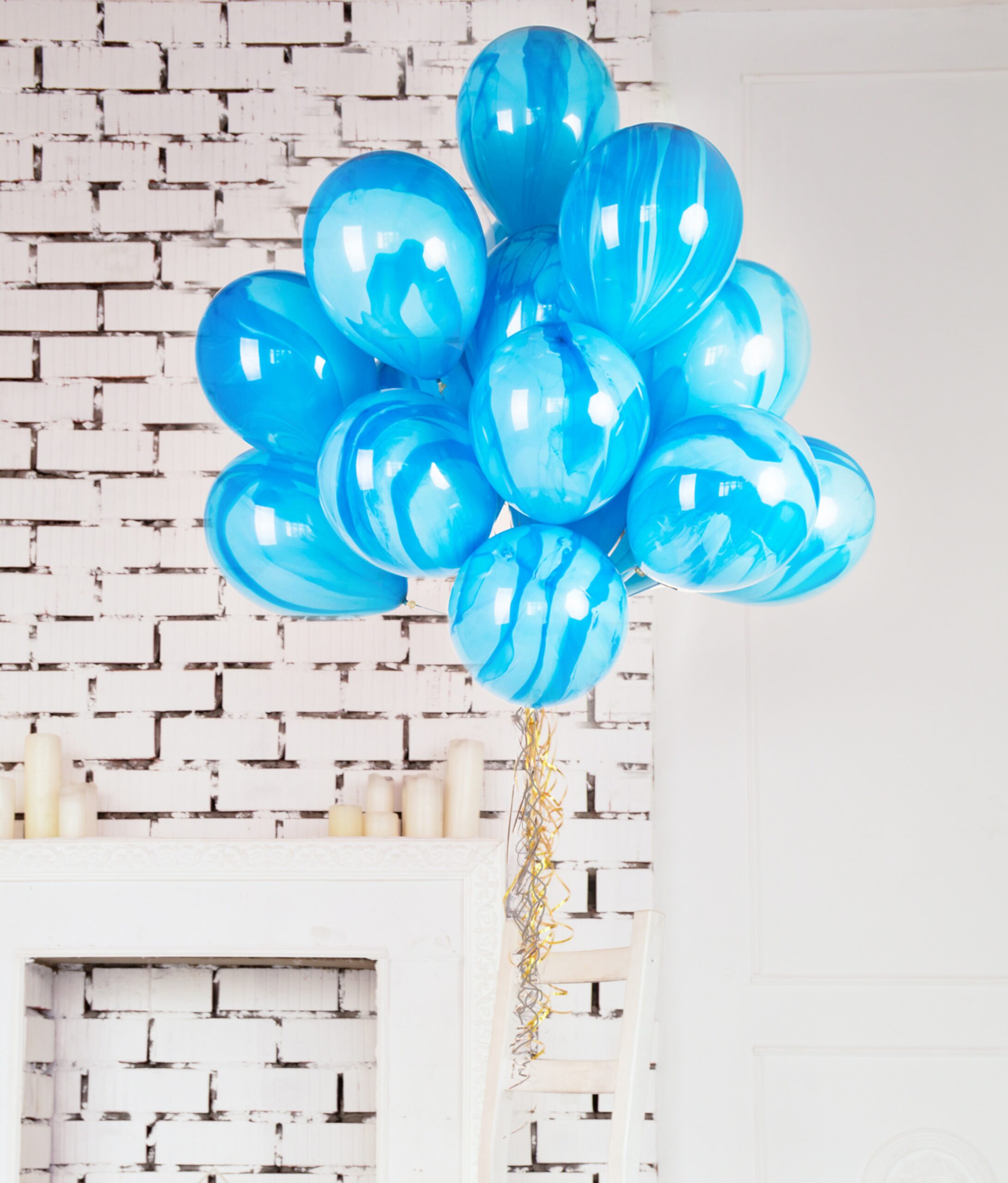 Blue balloons against a white brick background