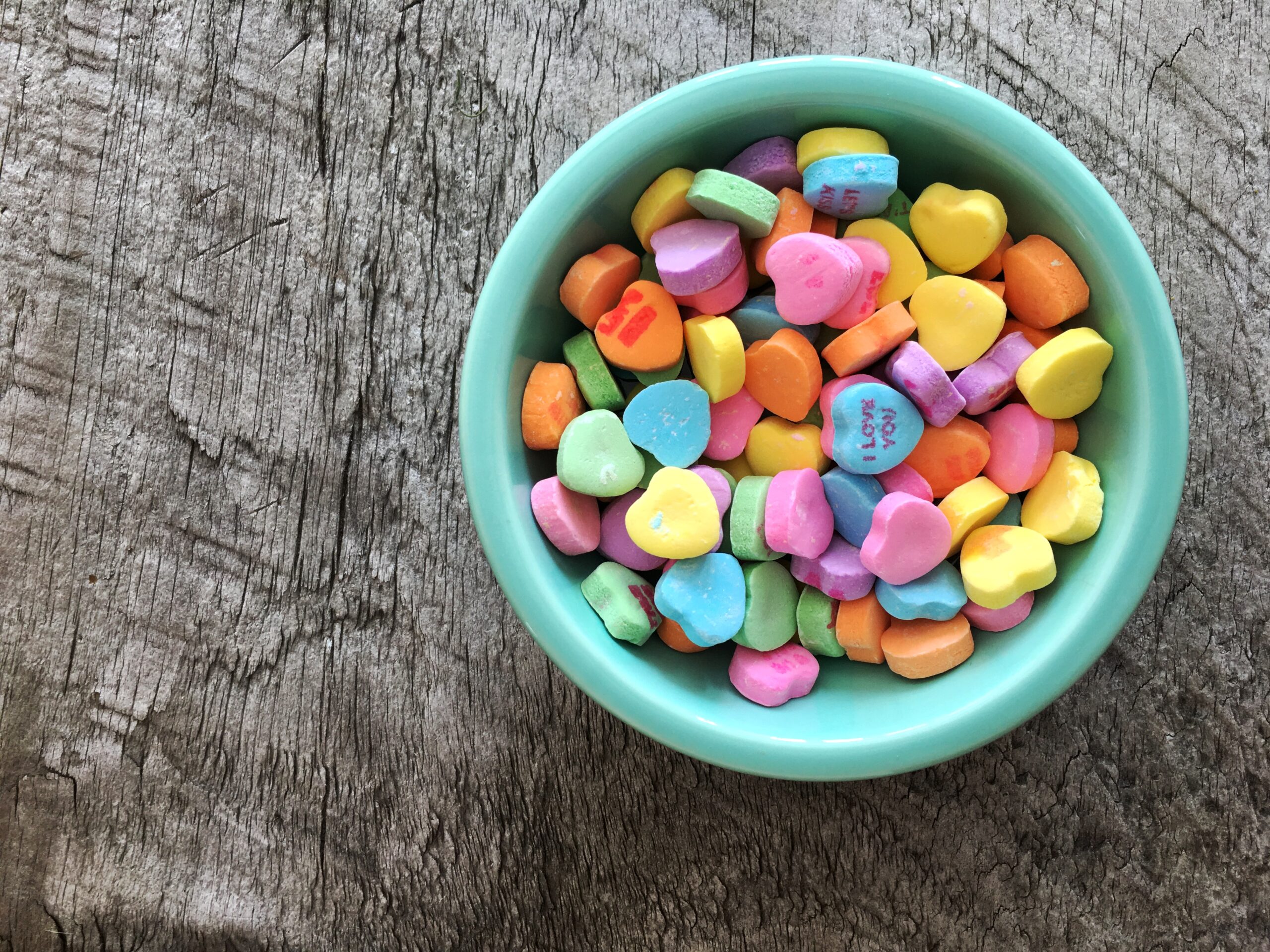 Candy hearts in a turquoise bowl