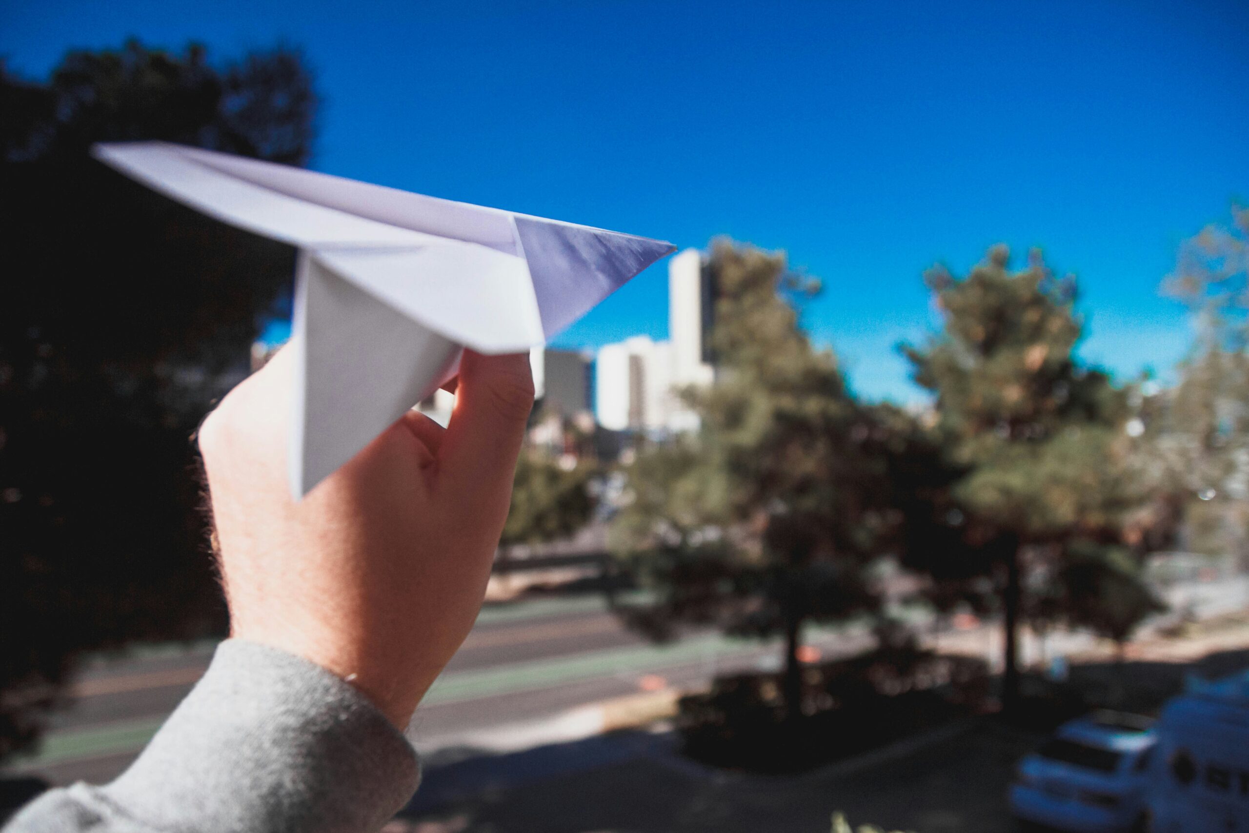 Hand holding paper plane, ready to launch