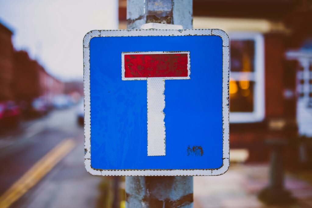 Road sign with the dead end symbol on it